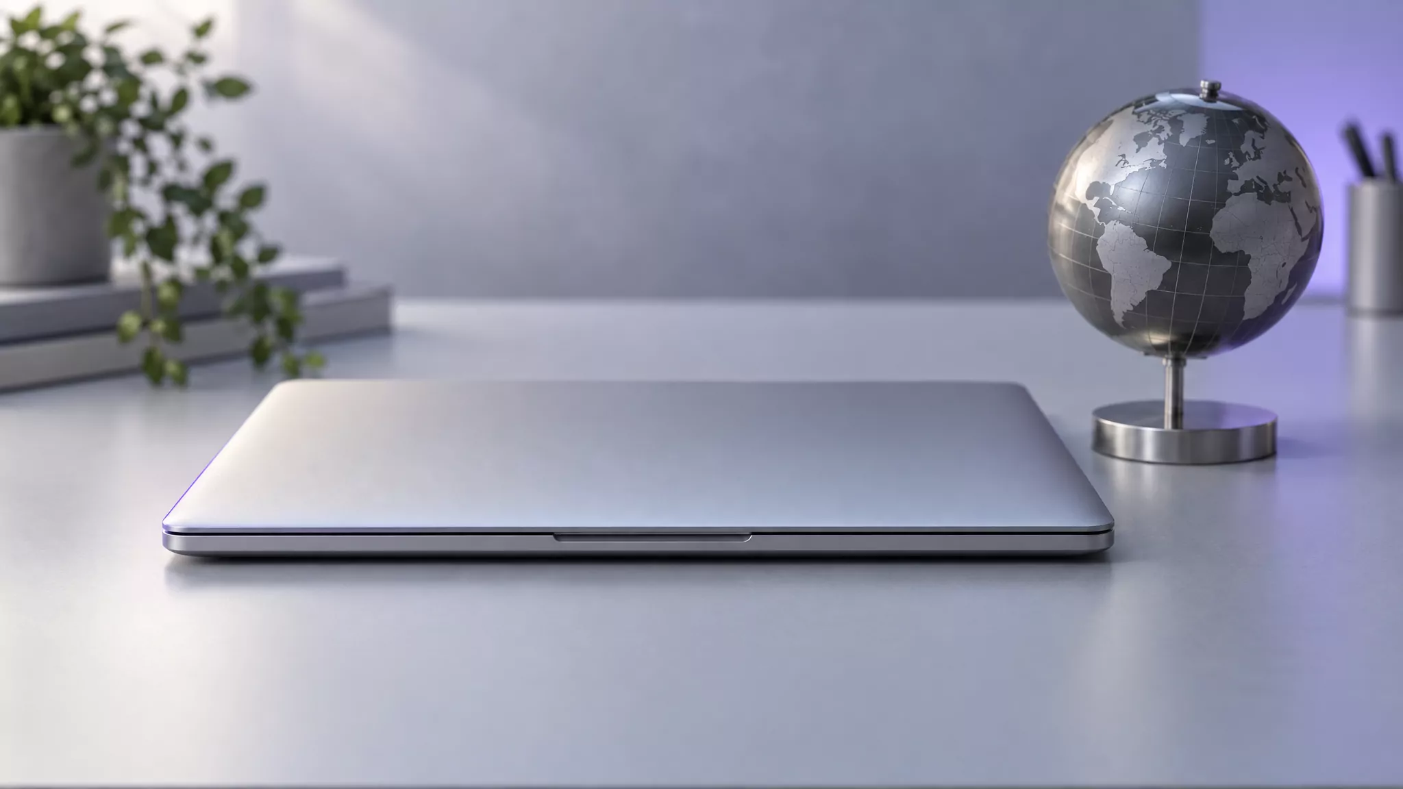 Closed laptop beside a small metal desk globe, a calm start to uninstall GlobalProtect on Mac