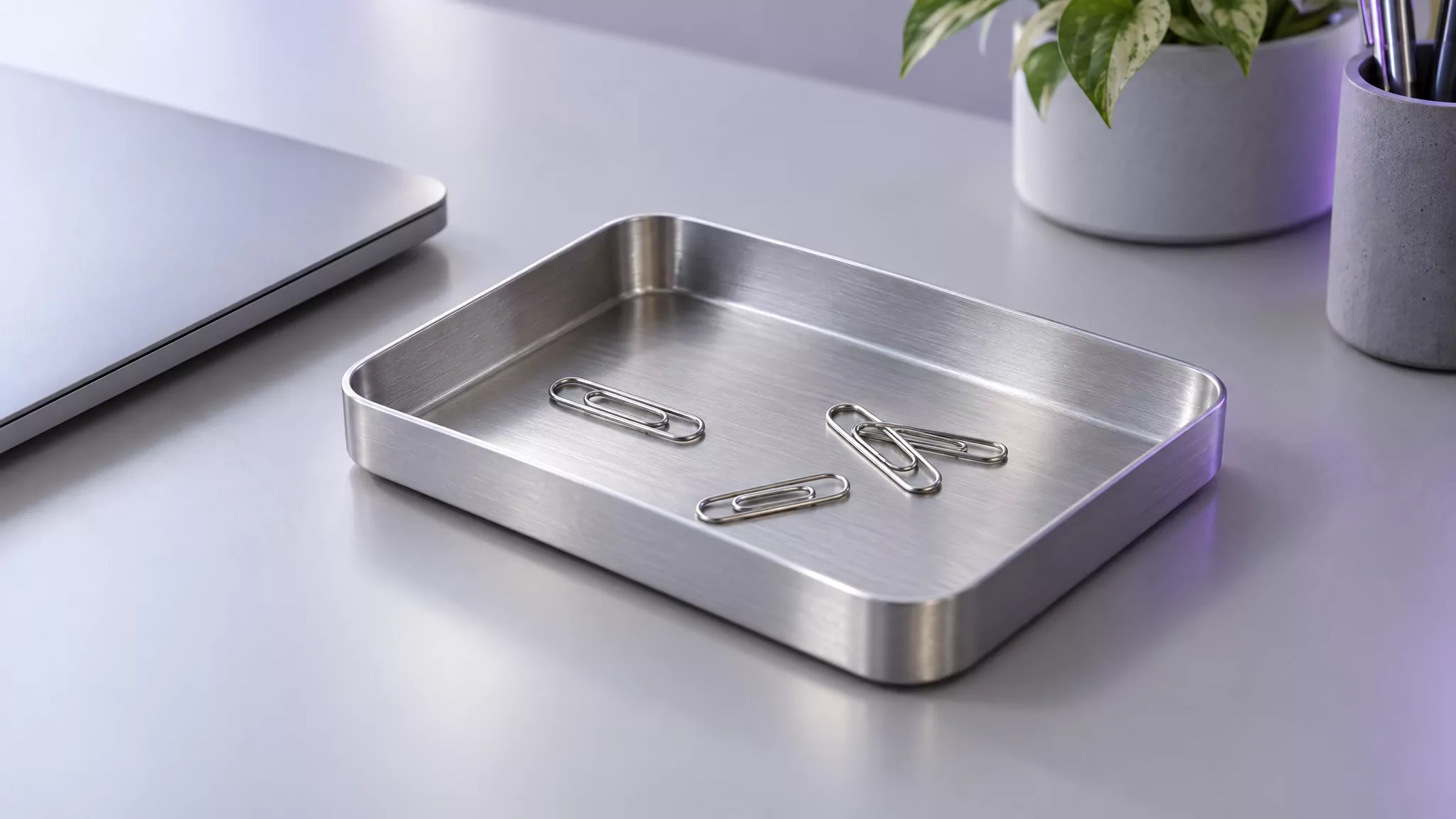Empty metal desk tray with loose paper clips, standing for the leftover files after you uninstall Spotify from Mac