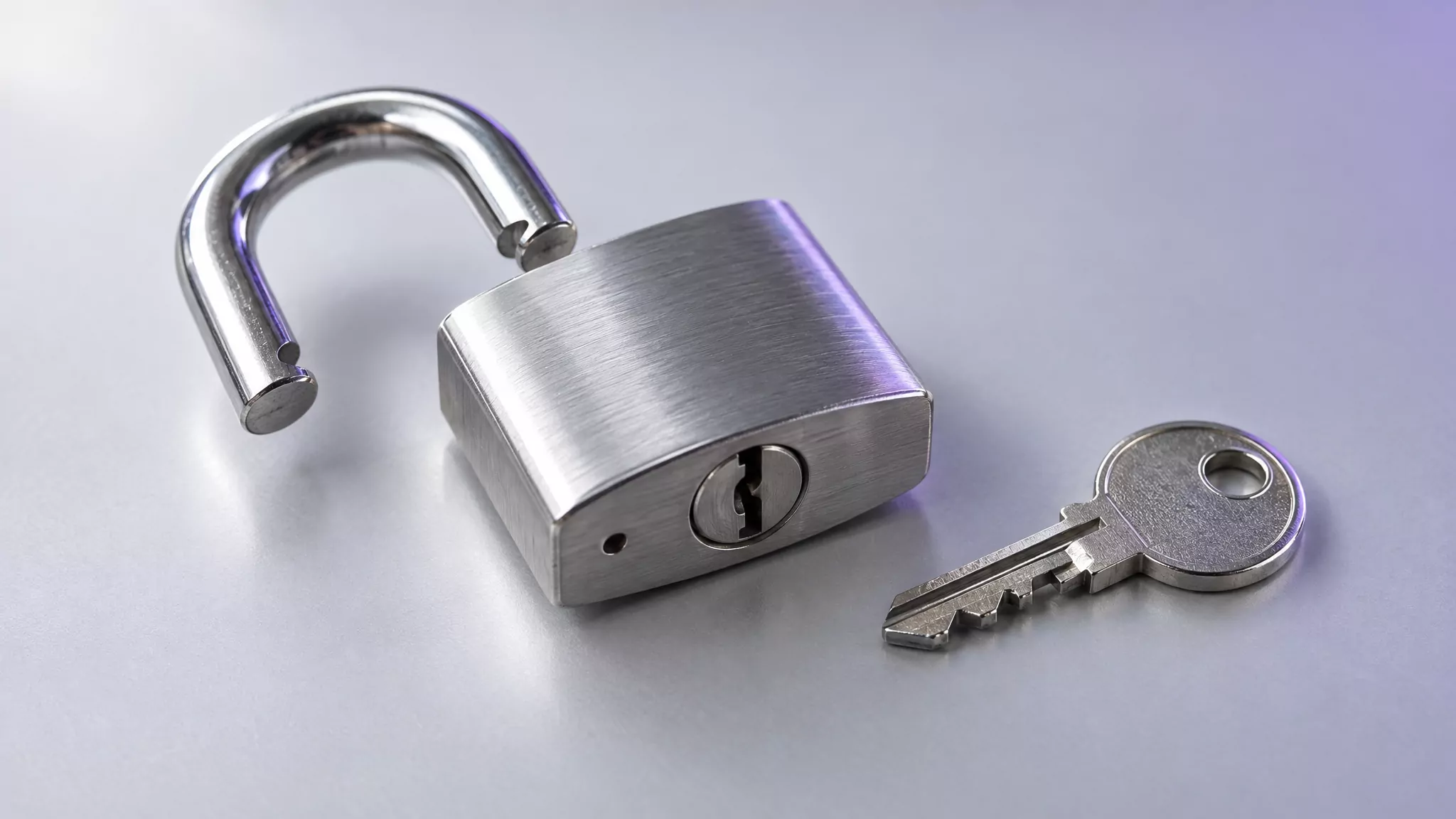 Open steel padlock beside a key, representing Steam login items and background items being removed on Mac