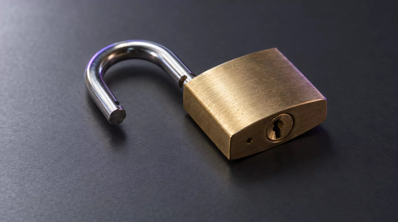 Open padlock on a dark desk, standing for a Dropbox permission withdrawn on a Mac