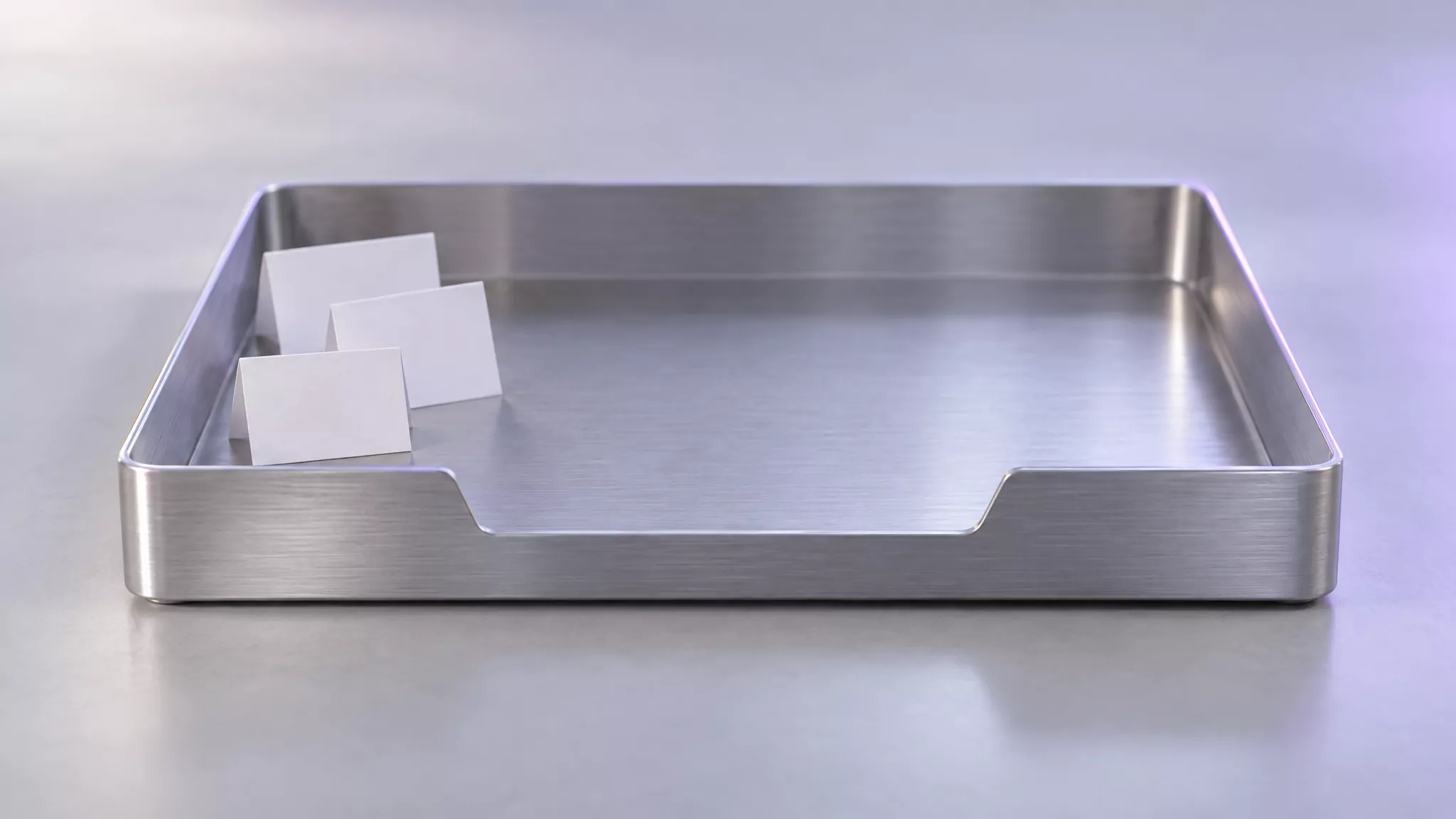 Empty metal desk tray with three blank cards left in one corner, like Grammarly leftovers in the Mac Library folder