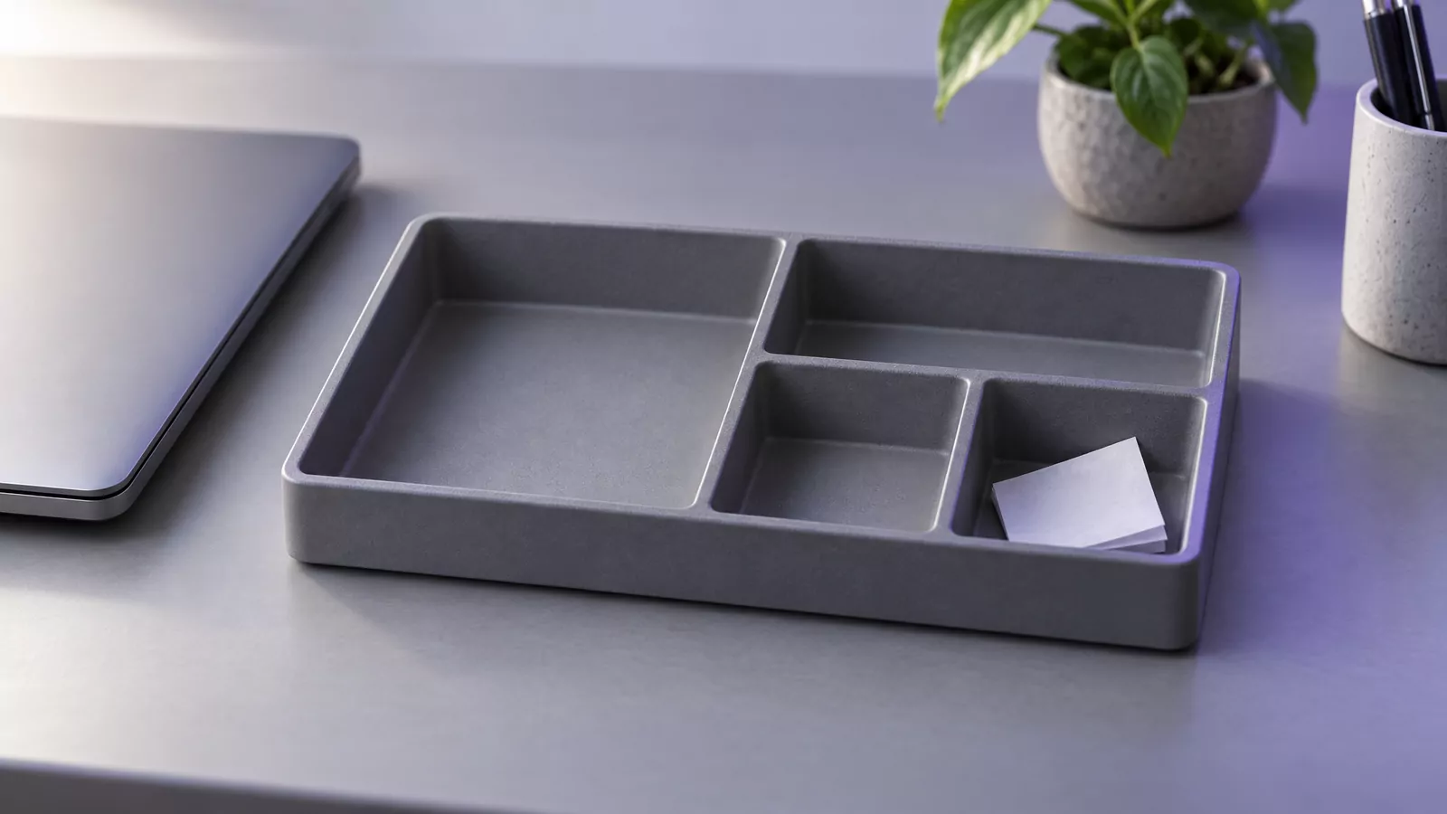 Empty desk tray with one folded note beside a laptop, standing for Adobe Acrobat leftover files on a Mac